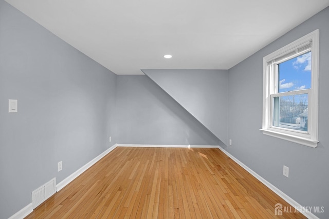 additional living space featuring light wood-style flooring, recessed lighting, visible vents, and baseboards