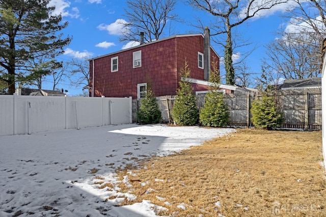 view of property exterior featuring a chimney and fence