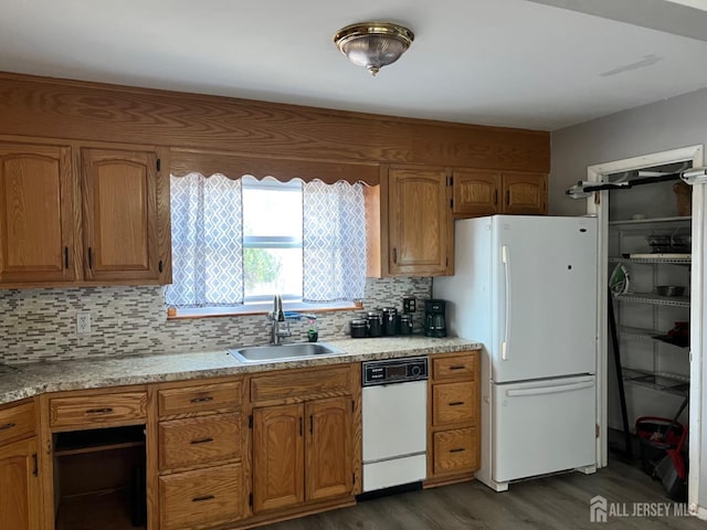 kitchen with dark wood-type flooring, white appliances, sink, and backsplash