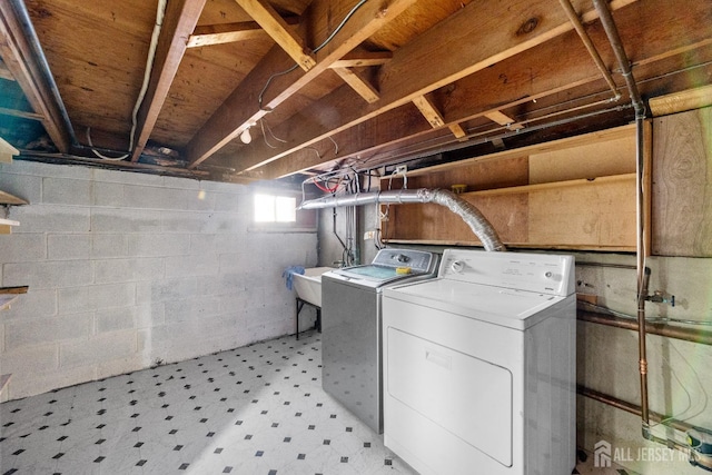 washroom featuring a sink, laundry area, washing machine and dryer, and light floors