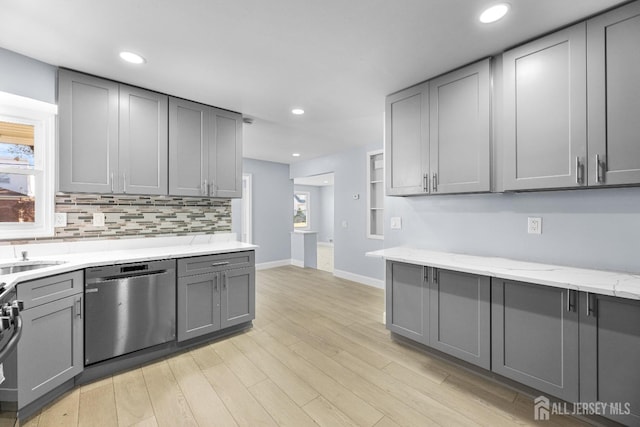 kitchen featuring dishwasher, backsplash, gray cabinets, and light wood-style flooring