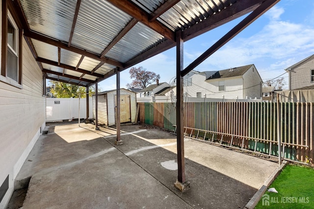 view of patio featuring a storage shed, an outdoor structure, a fenced backyard, and a residential view