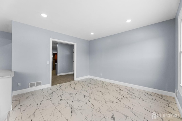 unfurnished room with recessed lighting, marble finish floor, visible vents, and baseboards