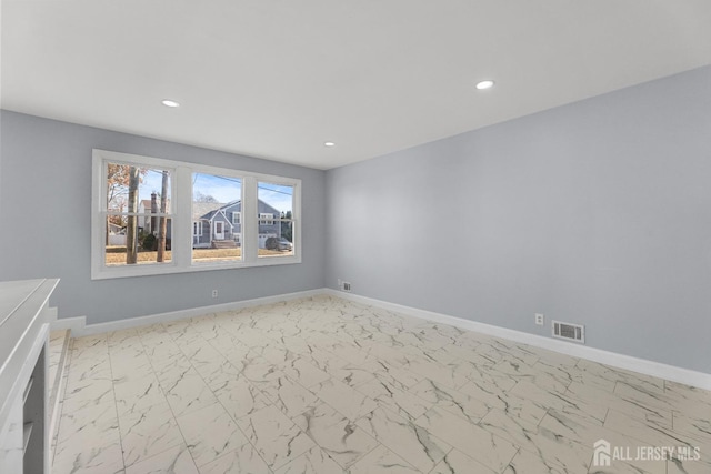 unfurnished room with recessed lighting, marble finish floor, visible vents, and baseboards