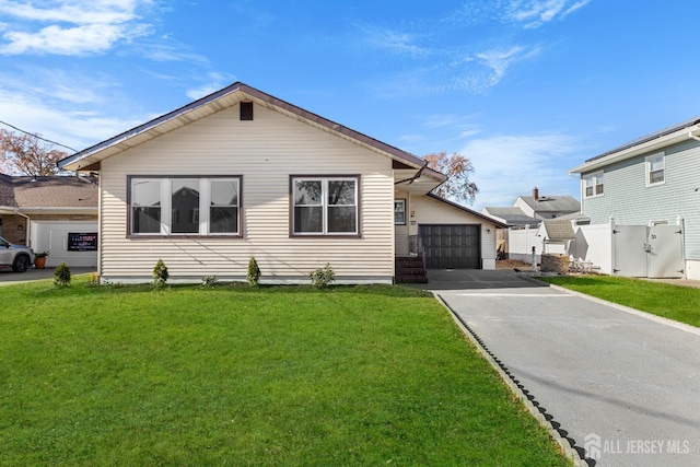 view of front of house featuring a garage, fence, and a front yard