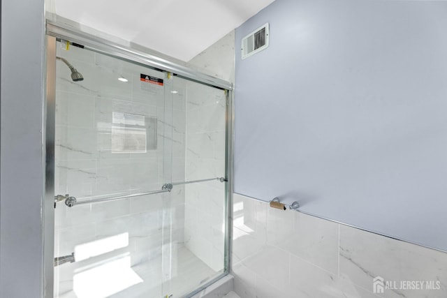 bathroom featuring a stall shower and visible vents