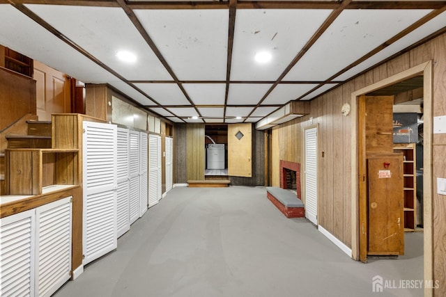 interior space featuring water heater, a fireplace, and wood walls