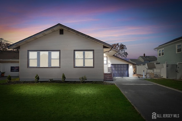 view of front of house with a garage, a yard, an outbuilding, and driveway