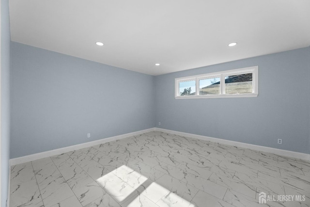 empty room with marble finish floor, recessed lighting, and baseboards