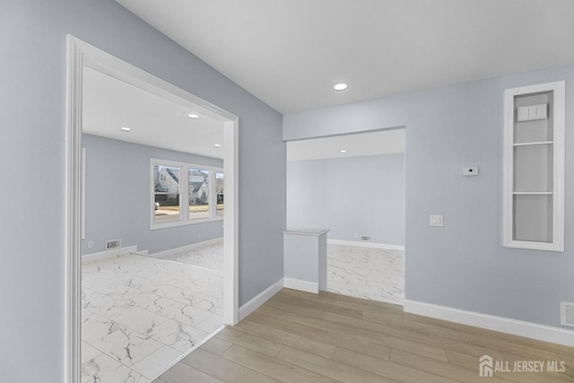 hallway featuring marble finish floor, recessed lighting, visible vents, and baseboards