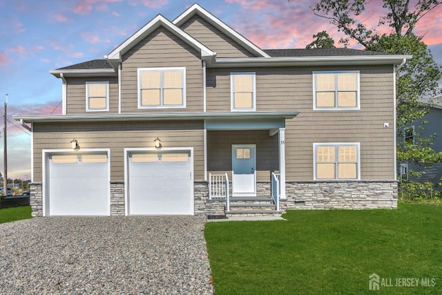 view of front of property featuring a garage, covered porch, and a lawn