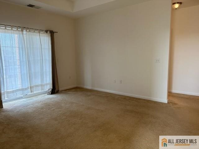 unfurnished room with plenty of natural light, visible vents, and carpet floors