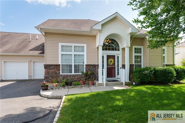 704 Schindler Dr, South Brunswick, NJ 08852 - view of front facade featuring asphalt driveway, a front lawn, an attached garage, and a shingled roof