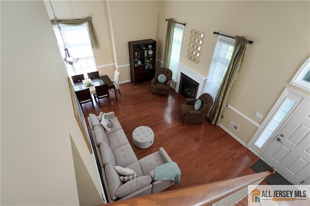704 Schindler Dr, South Brunswick, NJ 08852 - living area featuring wood finished floors, a towering ceiling, a fireplace, and a chandelier
