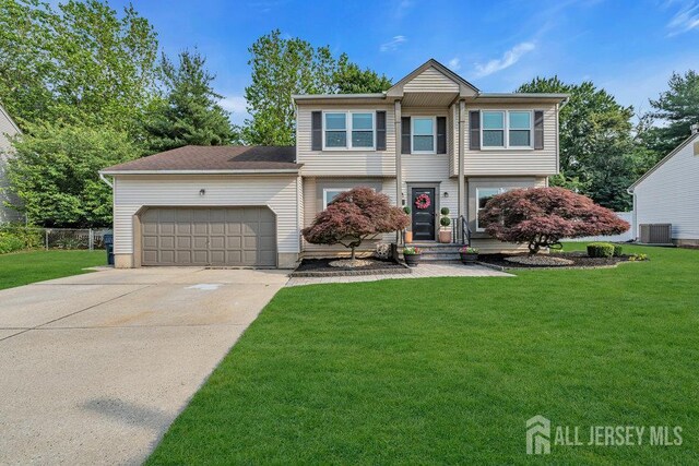 61 Lynn Ct, North Brunswick, NJ 08902 - view of front of home with concrete driveway, a front yard, and an attached garage