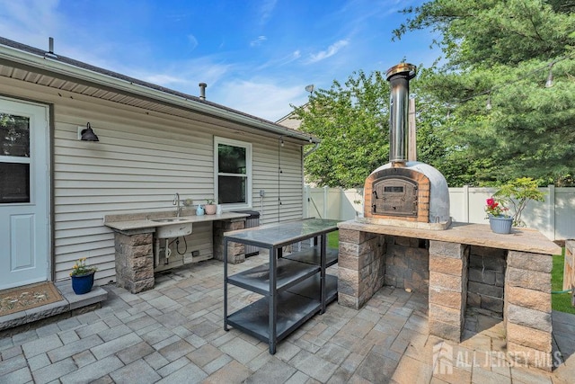 61 Lynn Ct, North Brunswick, NJ 08902 - fenced backyard with a patio area and exterior kitchen