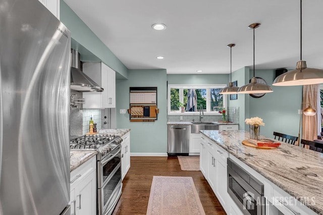 61 Lynn Ct, North Brunswick, NJ 08902 - kitchen featuring appliances with stainless steel finishes, wall chimney exhaust hood, decorative backsplash, light stone counters, and recessed lighting