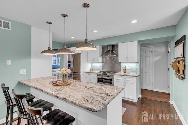 61 Lynn Ct, North Brunswick, NJ 08902 - kitchen with stainless steel appliances, wall chimney range hood, tasteful backsplash, white cabinets, and recessed lighting