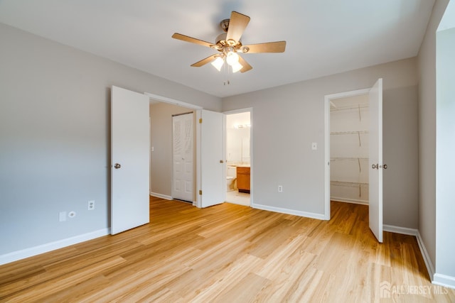 1604 Mulberry Ct, South Brunswick, NJ 08852 - unfurnished bedroom with light wood-type flooring, a walk in closet, connected bathroom, and a ceiling fan