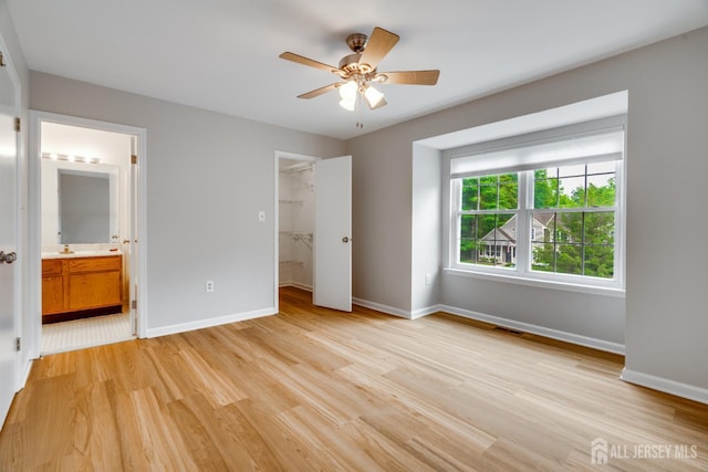 1604 Mulberry Ct, South Brunswick, NJ 08852 - unfurnished bedroom featuring light wood-style floors, a walk in closet, connected bathroom, and ceiling fan