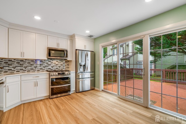 1604 Mulberry Ct, South Brunswick, NJ 08852 - kitchen with appliances with stainless steel finishes, light wood-style floors, light countertops, backsplash, and white cabinetry