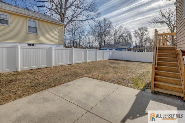 view of yard featuring a patio, a fenced backyard, and stairway