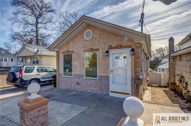 view of front of home featuring brick siding and fence
