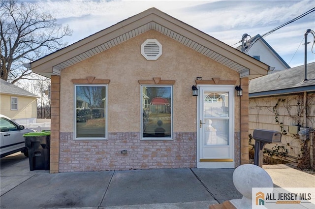 view of front of house featuring stone siding and stucco siding