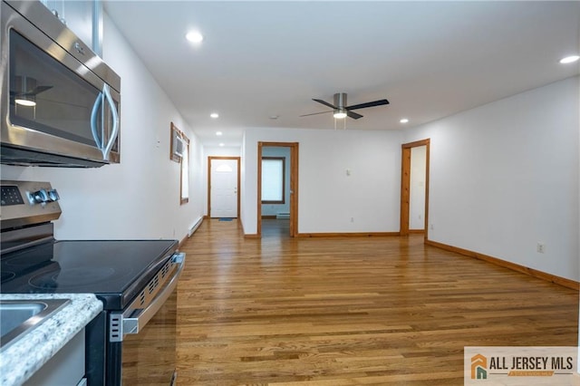 kitchen with light wood-type flooring, a ceiling fan, recessed lighting, stainless steel appliances, and baseboards