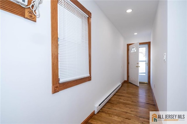 hall with a baseboard radiator, recessed lighting, wood finished floors, and baseboards