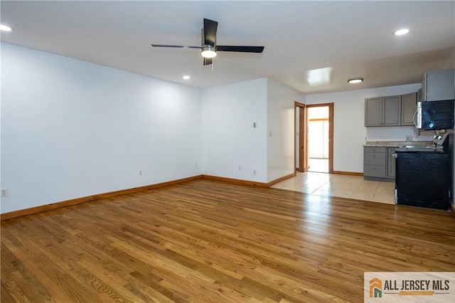 unfurnished living room featuring baseboards, light wood finished floors, recessed lighting, and a ceiling fan