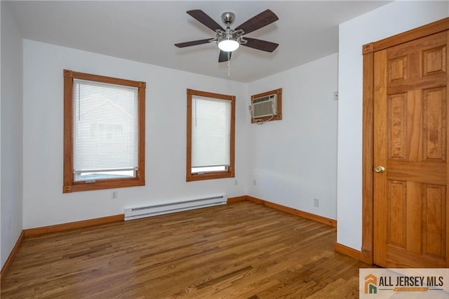 604 Greenwood Ave, Old Bridge, NJ 08879 - unfurnished room featuring baseboard heating, a wall mounted AC, wood finished floors, baseboards, and ceiling fan