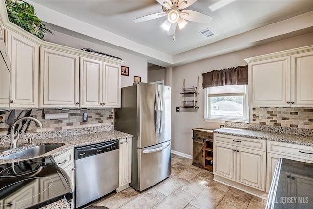 97 Boehmhurst Ave, Sayreville, NJ 08872 - kitchen with appliances with stainless steel finishes, cream cabinetry, backsplash, ceiling fan, and light stone counters