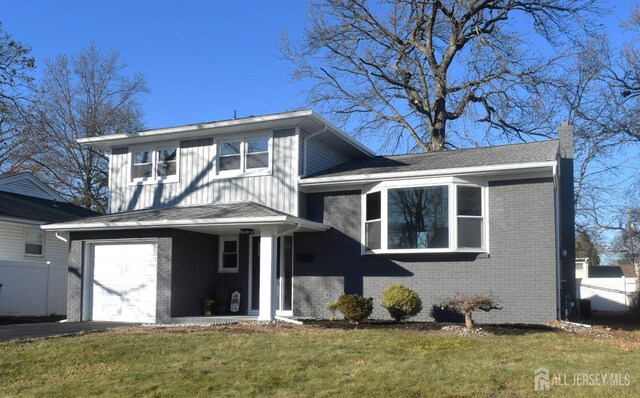 view of front of house with a front yard and a garage