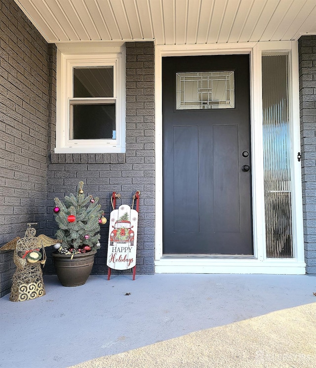 doorway to property featuring brick siding