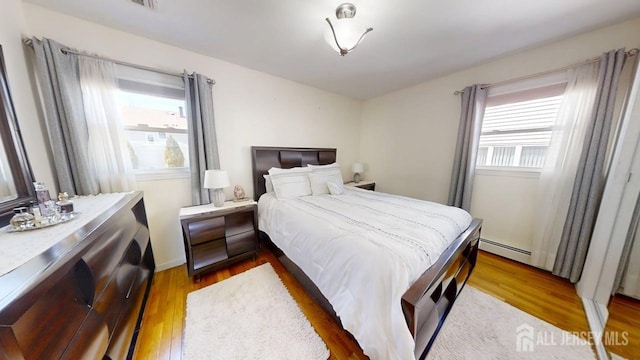 45 Maryknoll Rd, Menlo Park Terrace, NJ 08840 - bedroom featuring baseboard heating, multiple windows, and wood finished floors