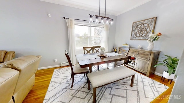 45 Maryknoll Rd, Menlo Park Terrace, NJ 08840 - dining area with a baseboard heating unit, a chandelier, ornamental molding, baseboards, and light wood-type flooring