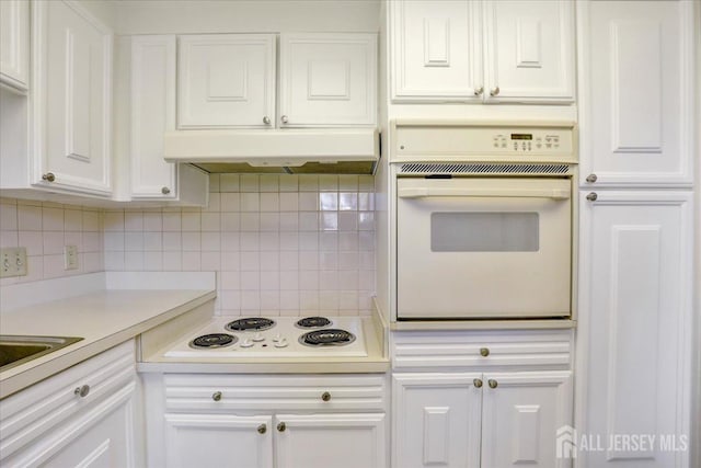 kitchen featuring white cabinetry, white appliances, and tasteful backsplash