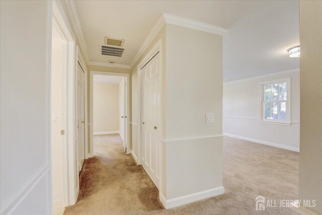 hallway with crown molding and light carpet