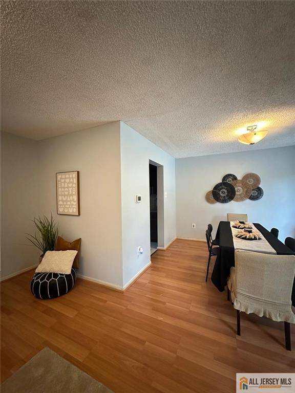 134 Hampshire Dr, Plainsboro, NJ 08536 - dining area with light wood-type flooring and a textured ceiling