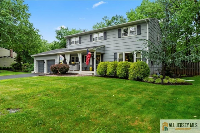 14 Devon Rd, Edison, NJ 08820 - colonial-style house featuring covered porch, driveway, a front lawn, and a garage