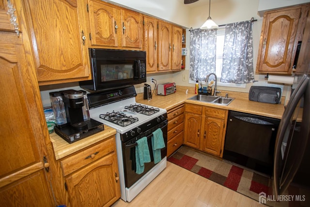 22 Woodcrest Dr, Old Bridge, NJ 08857 - kitchen with black appliances, brown cabinetry, light countertops, light wood finished floors, and decorative light fixtures