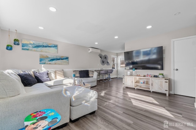 living room with a wall unit AC and wood-type flooring