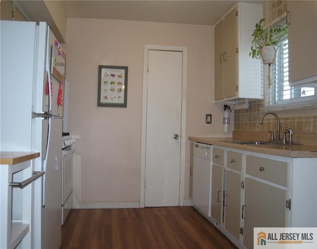 kitchen with backsplash, dark wood-style flooring, a sink, light countertops, and white appliances