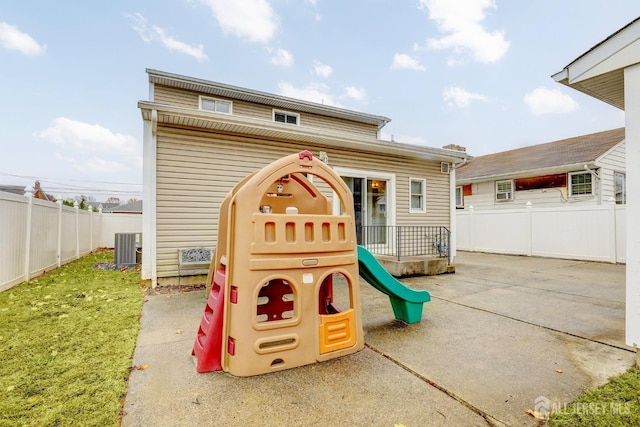 view of playground with central air condition unit and a patio