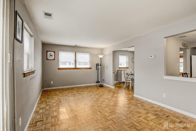 unfurnished room with light parquet floors and a healthy amount of sunlight