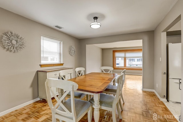 dining room featuring a healthy amount of sunlight and light parquet floors