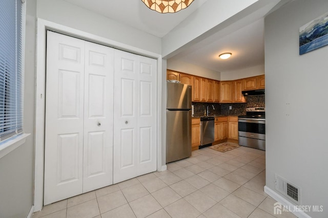 kitchen featuring light tile patterned floors, tasteful backsplash, visible vents, appliances with stainless steel finishes, and under cabinet range hood