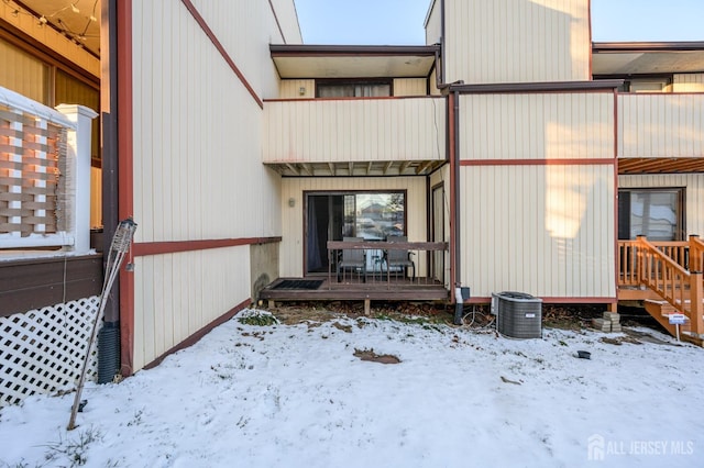 snow covered property entrance featuring a balcony