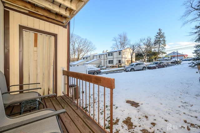 snow covered back of property featuring a residential view